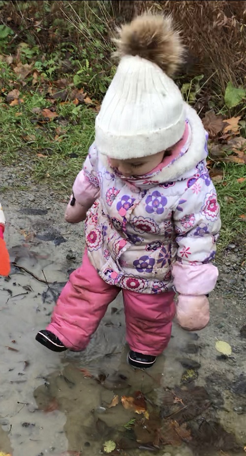 child walking in a puddle