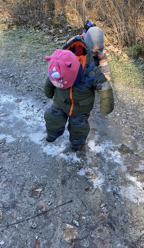 Child stomping on puddles that have turned to ice