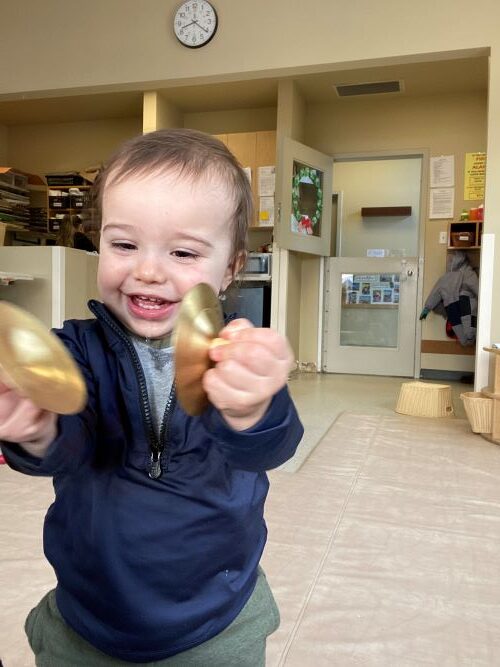 Little boy playing with mini cymbals.