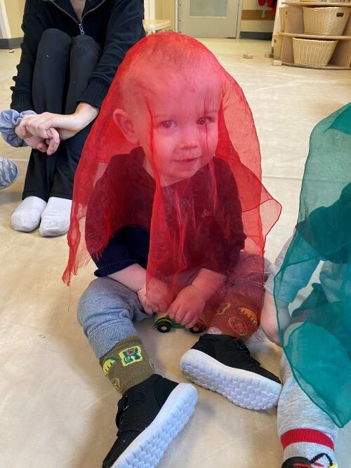 Little boy with red mesh cloth on his head.