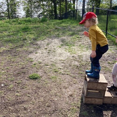 Boy getting ready to jump off a small wood block onto the ground.