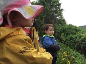 Two children outdoors on a spring day looking out to nature.