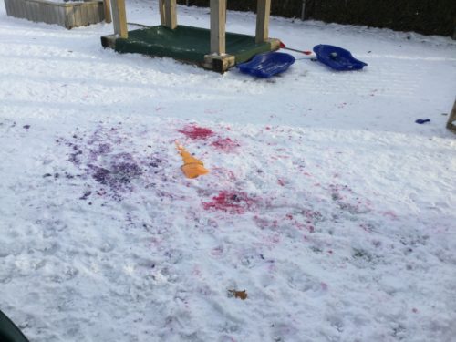 Children’s play area with colourful splashes of red, purple, and orange spray on the snow.