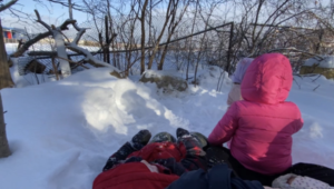 group of toddlers sitting on the snow waiting